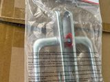 deux pièces métalliques se trouvent dans un emballage posé sur une boîte en carton