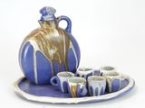 a blue and white plate with cups and a jug on it
