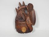 sculpture sur bois représentant un oiseau tenant une pièce de monnaie, sur un fond blanc