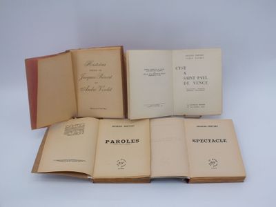 quatre livres ouverts posés les uns sur les autres sur une surface blanche
