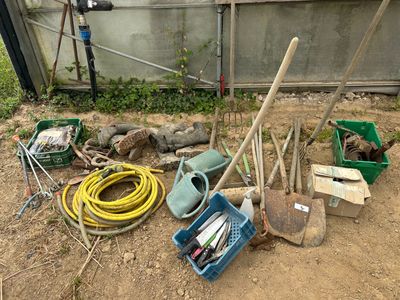 un tas d'outils de jardinage et d'autres outils par terre