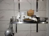 a shelf with a bunch of dishes and utensils on it