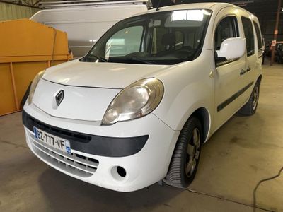 a small white car parked in a garage with a boat in the background