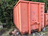 une benne à ordures posée au milieu d'un champ
