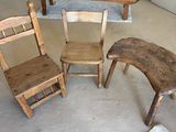 trois chaises en bois et une table dans un salon