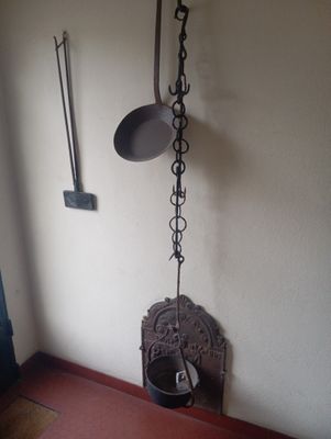une horloge murale accrochée au mur à côté d'une casserole et d'une poêle