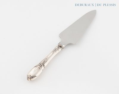 un couteau à gâteau en argent avec un manche en argent posé sur une surface blanche