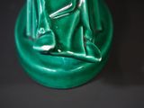 a green statue of a frog sitting on a green base