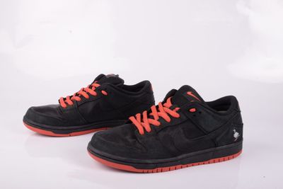 une paire de baskets noires et orange avec des lacets orange