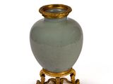 a vase that is sitting on a stand on a white surface
