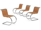 four chairs with a metal frame and wicker seat on a white background