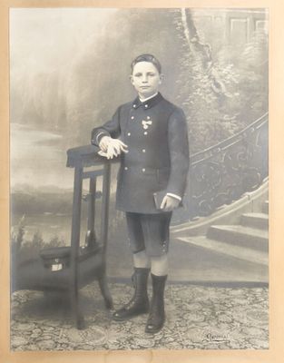 an old photo of a man in uniform standing next to a chair