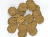 une pile de pièces d'or posée sur une surface blanche