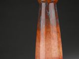 un vase en verre à la base rouge posé sur une table
