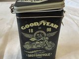 a black tin with a motorcycle on it on a bed