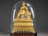 une horloge en or sous un dôme de verre sur une table