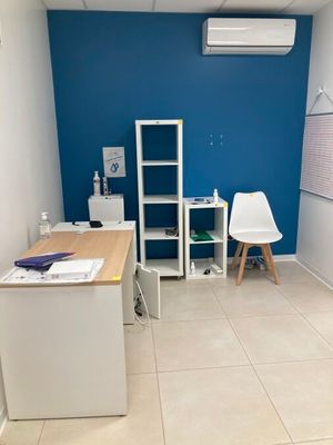une pièce équipée d'un bureau, d'une chaise et d'un réfrigérateur