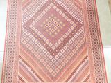 un tapis orange et rose posé sur un sol blanc
