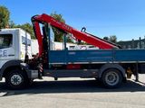 un camion bleu équipé d'une grue rouge à l'arrière