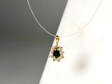 collier composé d'une pierre noire entourée de diamants blancs sur un fond blanc