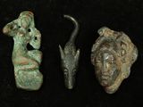 three pieces of ancient artifacts are displayed on a black surface