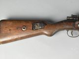 a close up of a rifle on a table with a white background