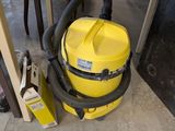 a yellow vacuum that is on the floor next to a table