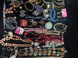 an assortment of assorted necklaces and bracelets on a black surface