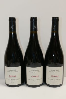 three bottles of wine are lined up on a table