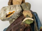 a figurine of a man holding a knife and a bag