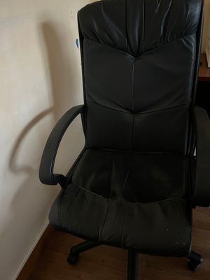 une chaise de bureau en cuir noir dans un coin de la pièce
