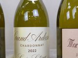 three bottles of wine are lined up on a table