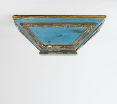 a blue and gold painted shelf on a white wall