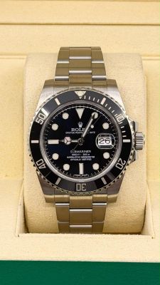 une montre Rolex dans un coffret sur fond vert