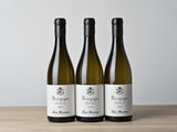 trois bouteilles de vin posées sur une table en bois