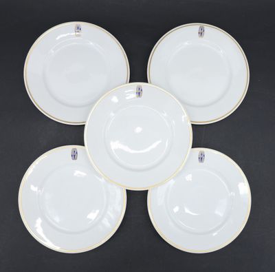four white plates with gold rims on a black background