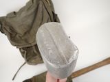a person holding a plastic object in front of a backpack