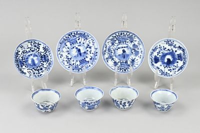 Plusieurs assiettes et tasses bleues et blanches sont alignées sur une table