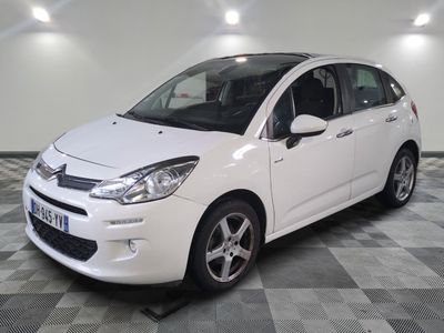 la petite voiture blanche est garée sur un carrelage à carreaux