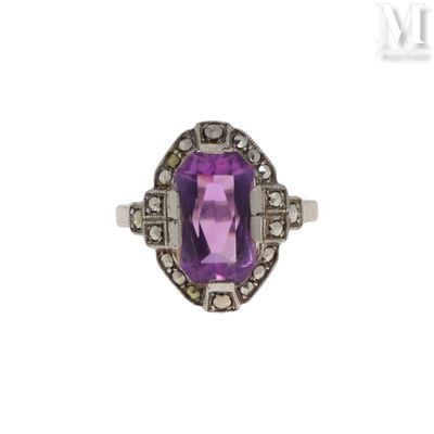 gros plan d'une bague avec une pierre violette entourée de diamants