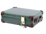 a green suitcase sitting on top of a white surface