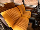a seat in the back of a bus with a yellow seat cover