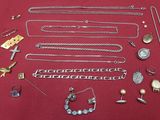 a lot of silver jewelry on a red surface