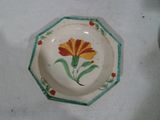 une assiette avec une fleur peinte sur une table