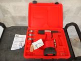 une mallette rouge contenant des outils, posée sur une table
