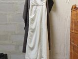 a white dress hanging on a clothes rack in a room