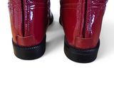 pair of red boots with black soles on a white surface