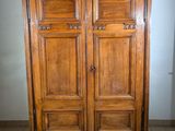 a wooden armoire in the middle of a tiled floor