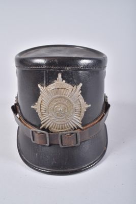 un petit chapeau noir orné d'un insigne doré