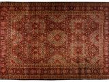 a red rug with a medallion design on a white background